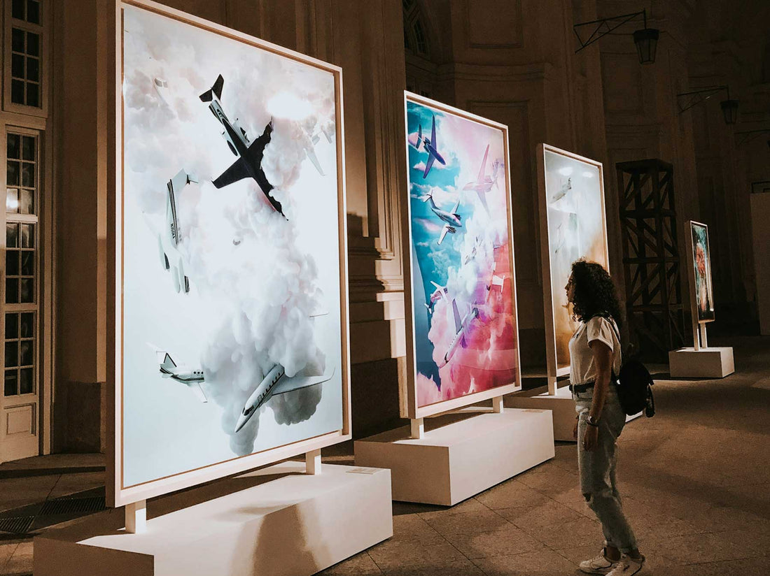 Large-scale works displayed on freestanding walls in a grand historic hall