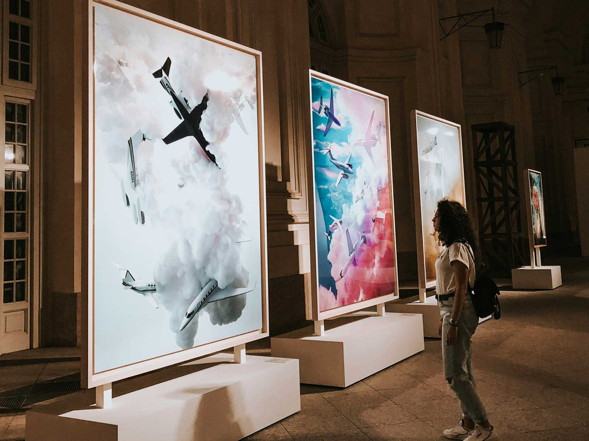 Large-scale works displayed on freestanding walls in a grand historic hall