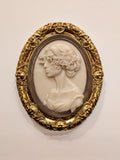 Charlotte Brontë Cameo — resin and 24k gold leaf by JoCa: an ivory cameo profile with curled hair, a glitch band across the eyes, in an ornate gold oval frame