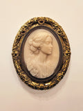 Emily Brontë Cameo — resin and 24k gold leaf by JoCa: an ivory cameo of a woman with swept-up hair in three-quarter view, in an ornate gold oval frame