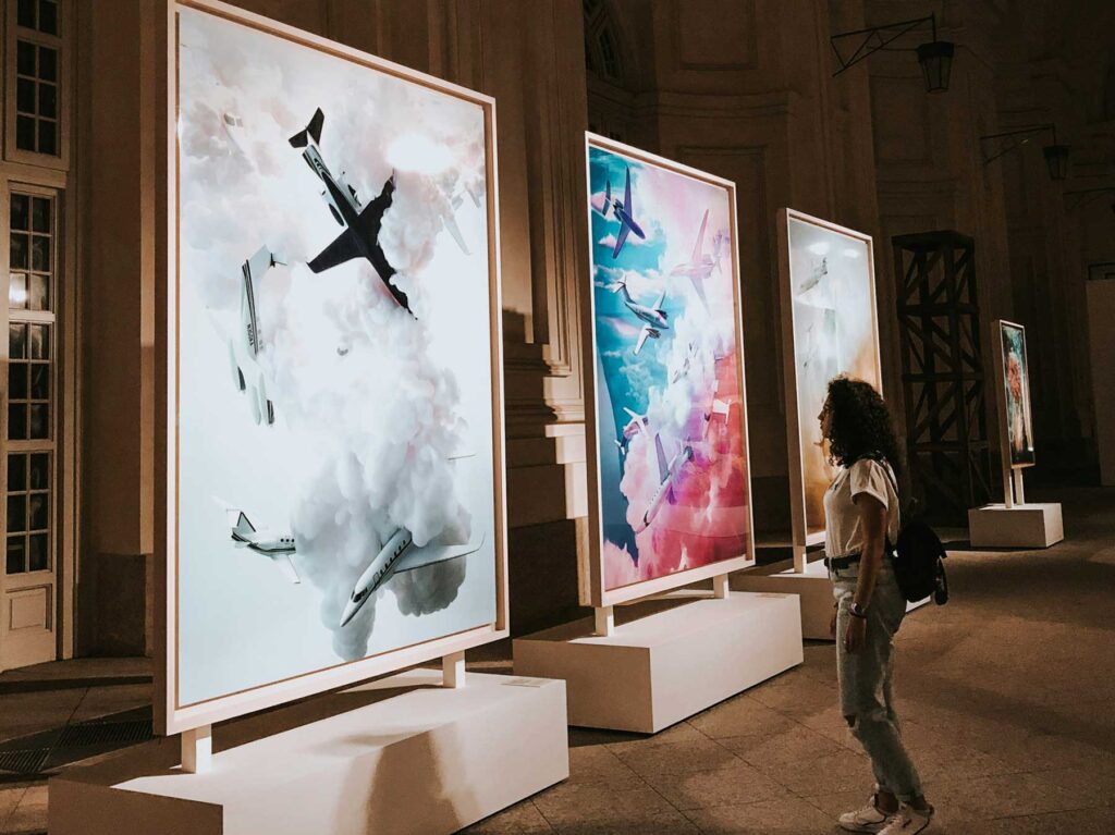 Large-scale works displayed on freestanding walls in a grand historic hall